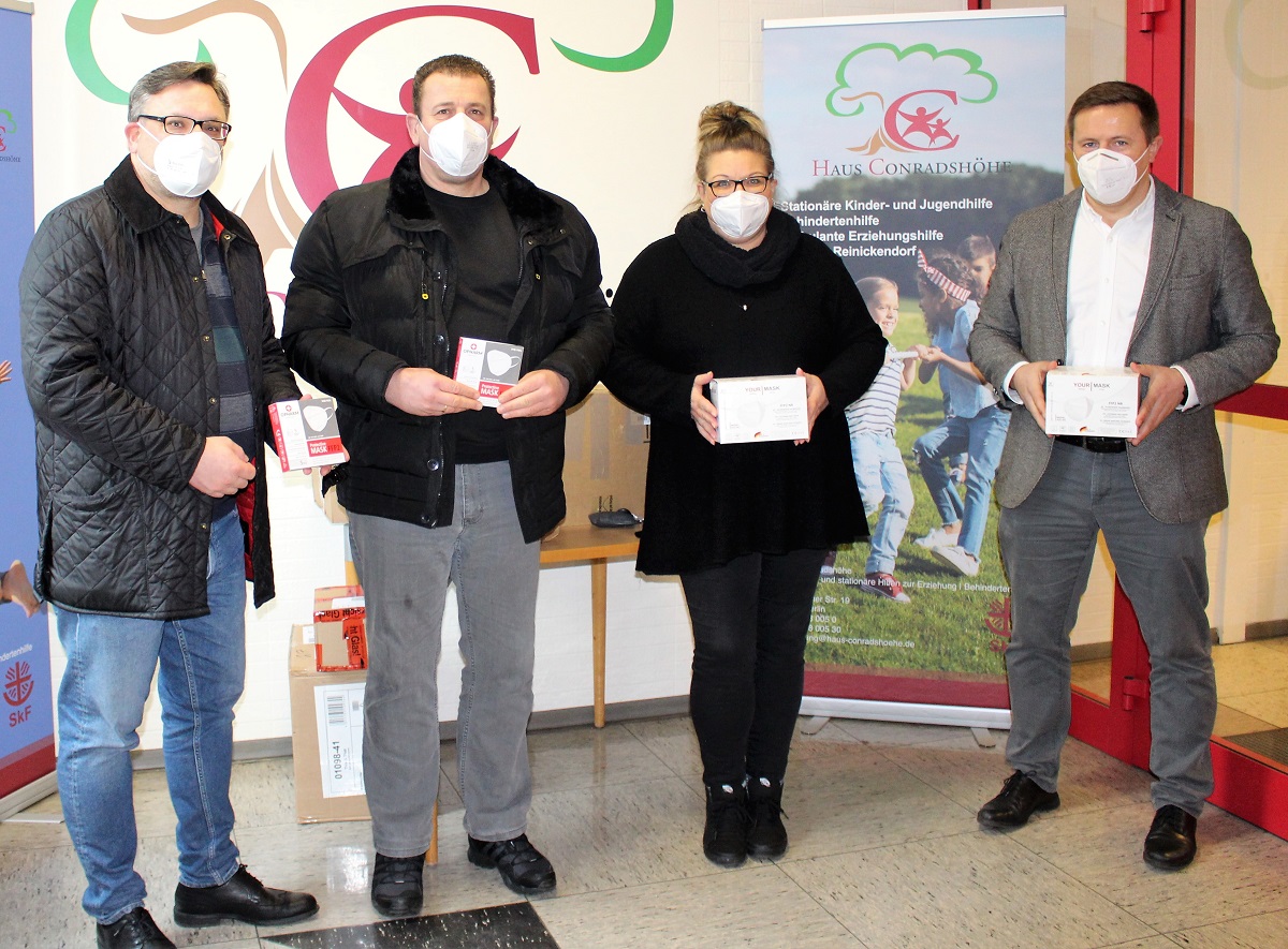 Wahlkreisabgeordneter Stephan Schmidt und BVV-Kandidat Martin Stelzer bei der bergabe der FFP-2 Masken an Marion Preu und Geschftsfhrer Remigusz Cisowski vom Haus Conradshhe (v.l.n.r.)